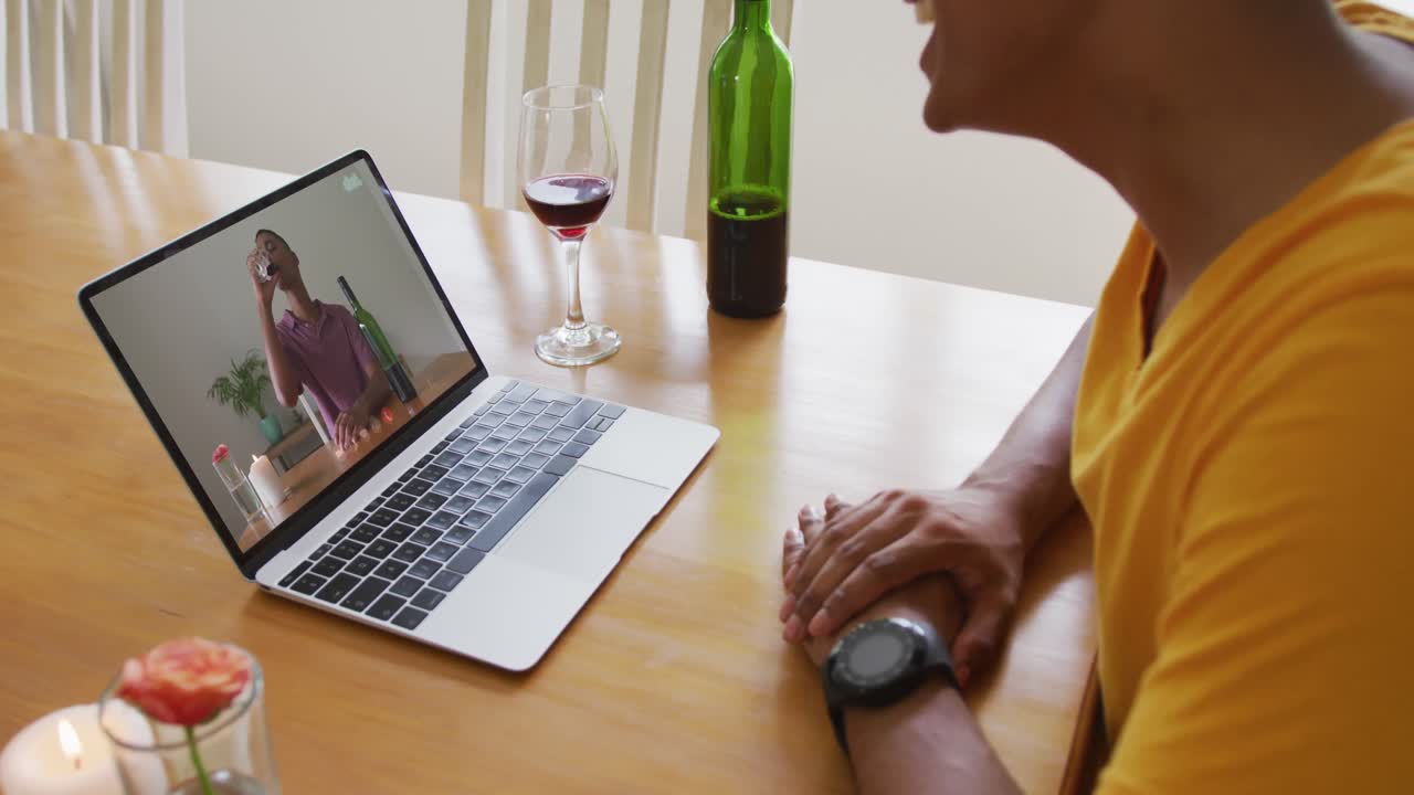 Mid section of african american man talking on video call on laptop at home