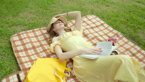 pretty young girl in yellow dress lying on the blanket - picnic in the park