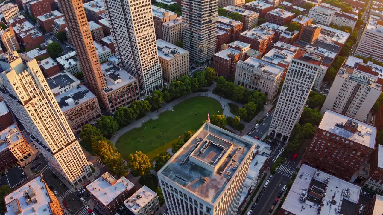 Aerial view of a cityscape at sunset, showcasing tall buildings and streets