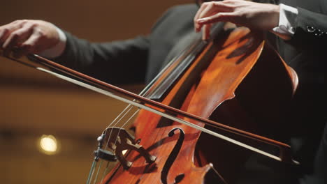 musician is playing violoncello closeup view of hands and bow on strings cellist on scene