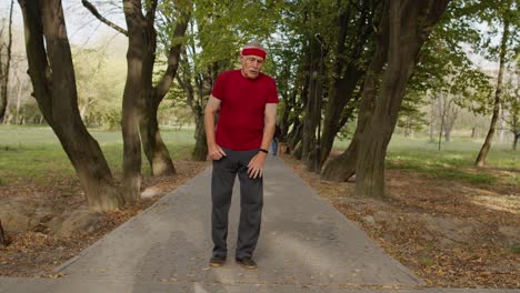 senior old man running in park and using smart watch, tracking result during fitness workout