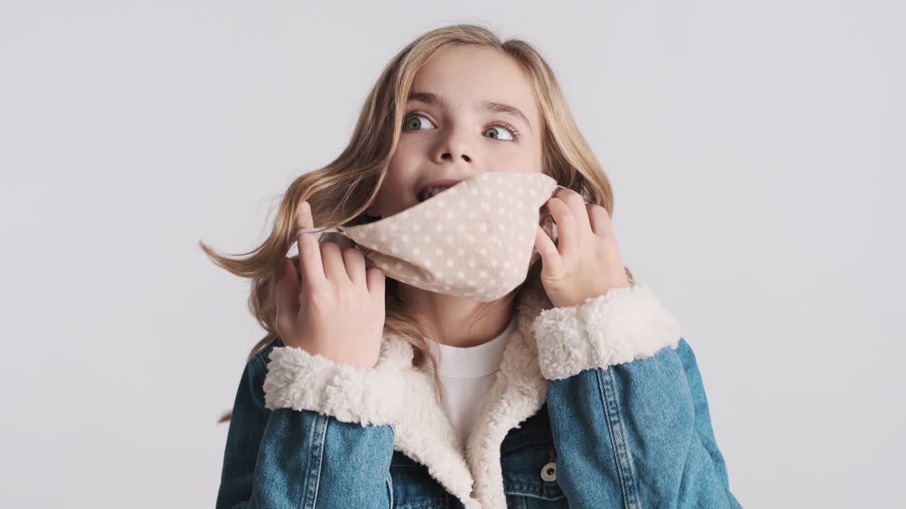 행복한 십대 백인 소녀가 얼굴 마스크를 벗고 있습니다.