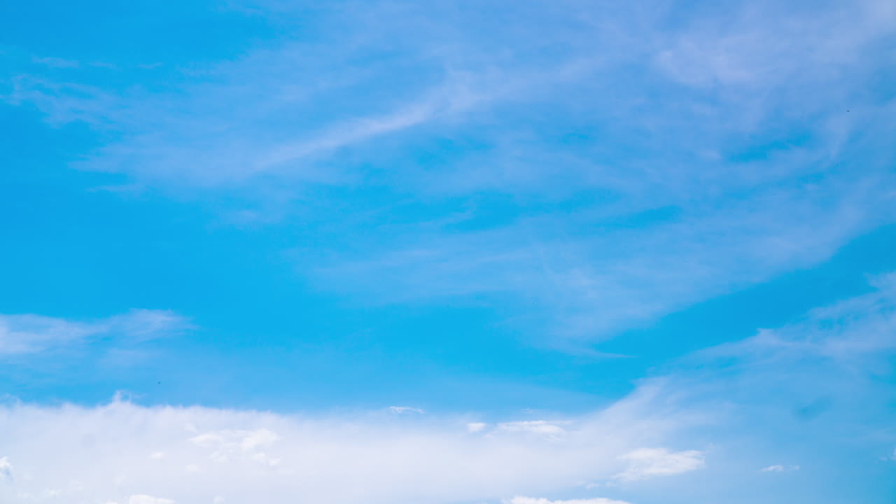 Stunning turquoise horizon with fluffy white clouds lit with bright sun. Soft cumulus clouds movement. Low angle view timelapse.