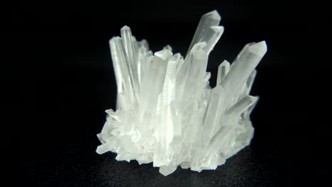 rotación sin problemas de un mineral blanco (cuarzo) frente a un fondo negro