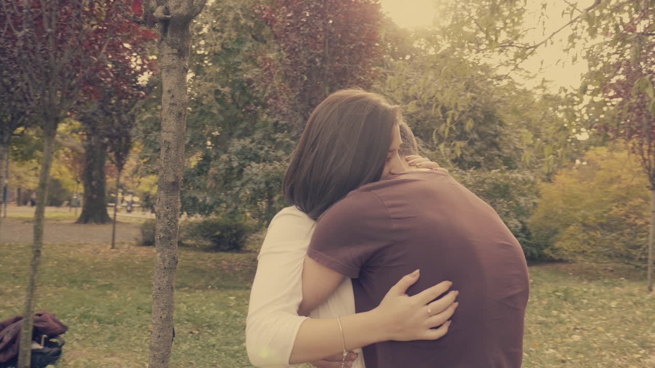 una pareja abrazándose en un parque.
