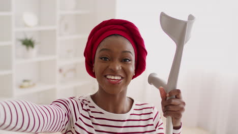 happy woman with crutch taking a selfie