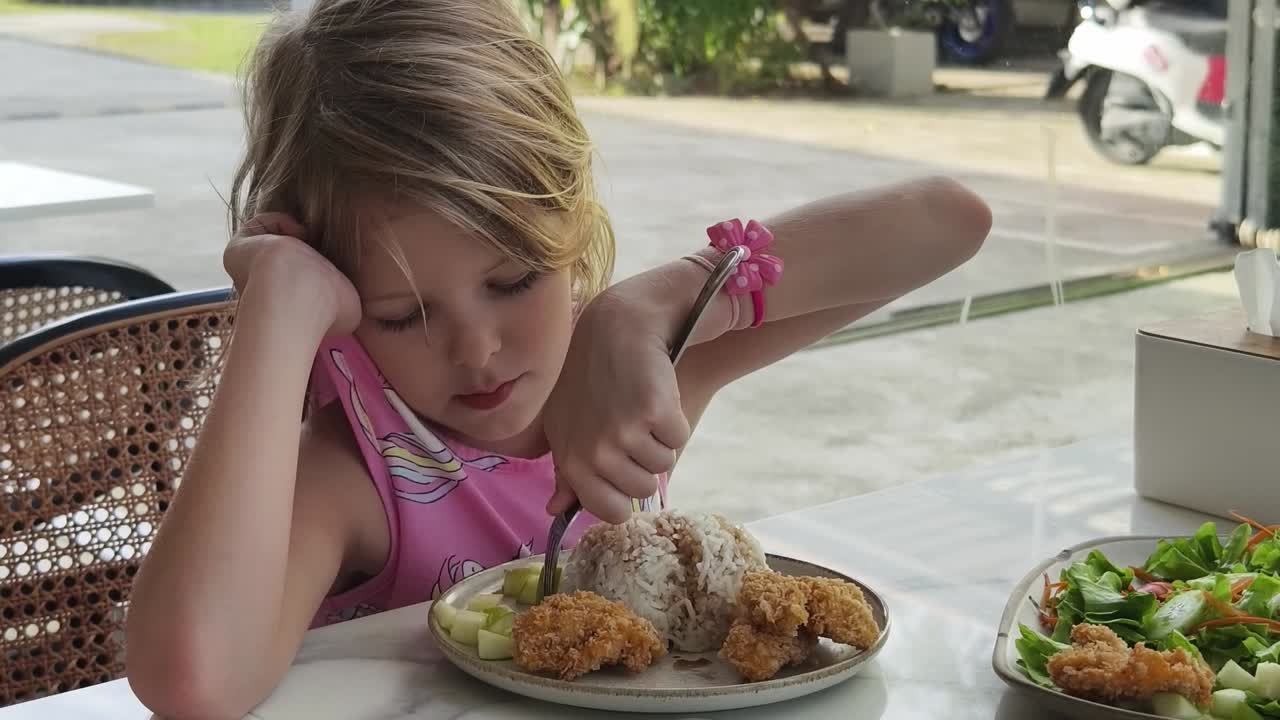 Bambina che pranza in un caffè