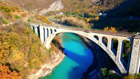 Stunning-aerial-4K-drone-footage-of-Solkan-arch-bridge-over-the-Soča-river,-a-majestic-stone-marvel-located-in-western-Slovenia