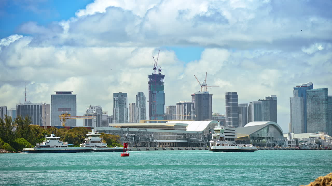 Miami, États-Unis, 16 avril 2026 : Horizon du port de Miami avec ferries et grues de construction. Vue sur le port industriel avec bateaux et bâtiments du centre-ville sous les nuages