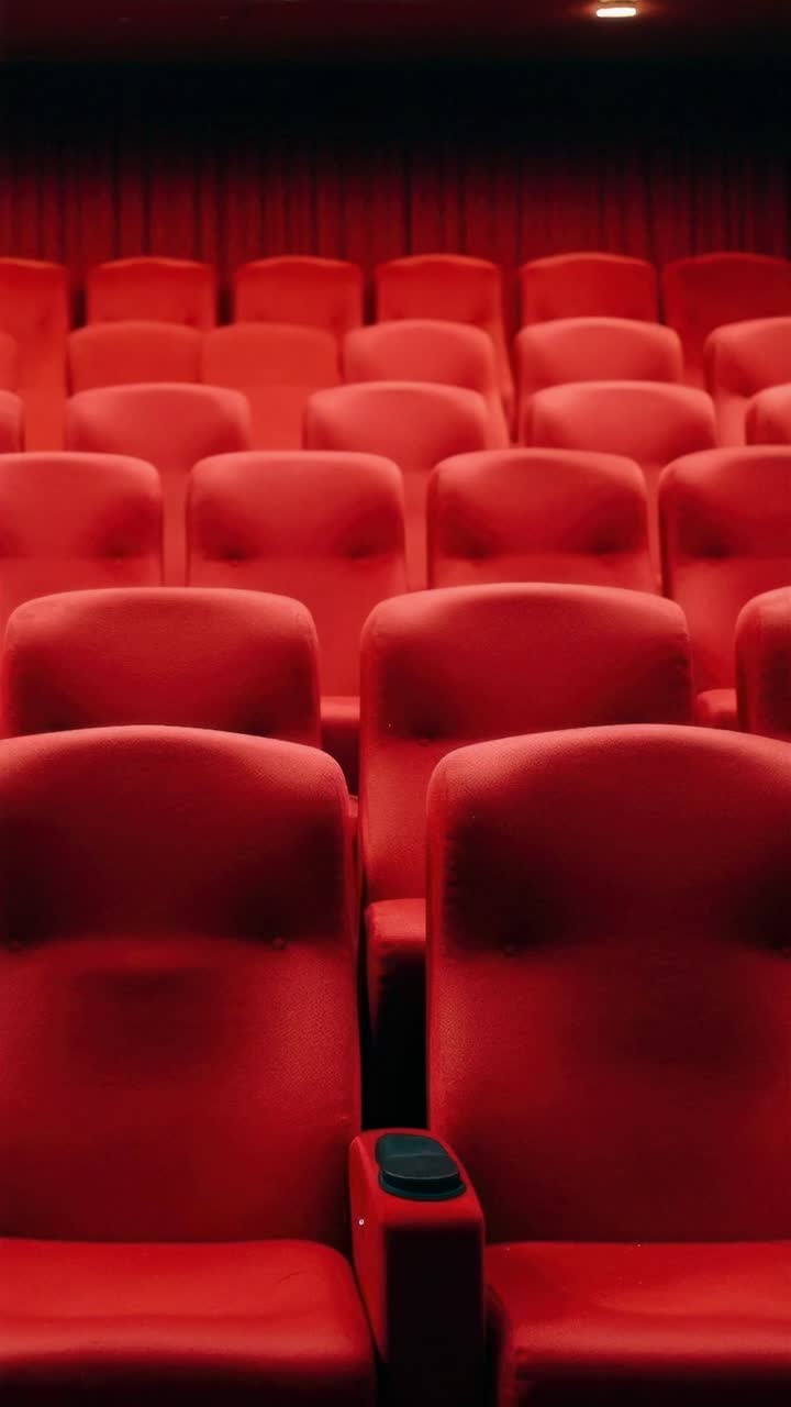 Sedili rossi vuoti di un teatro ripresi dal basso, che evocano un'atmosfera cinematografica, perfetta.