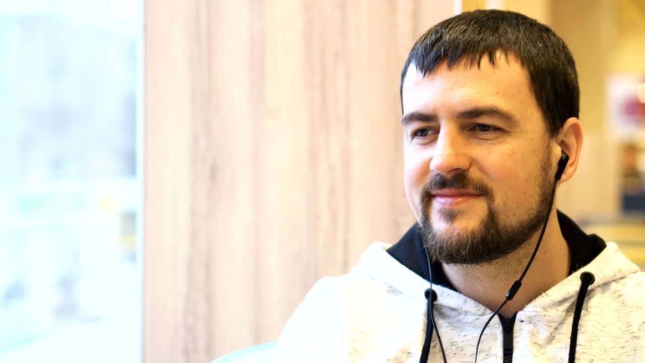 카페에서 카메라에 미소 짓는 젊은 남자.