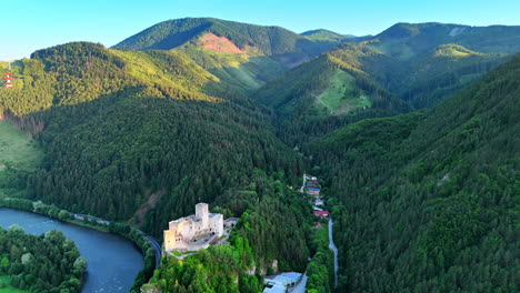 stunning view of the tatra mountains covered with pine-tree forests. aerial perspective on the strecno castle in northern slovakia.