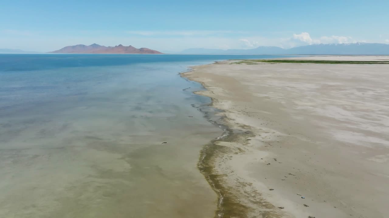Droneopptak som beveger seg fremover og senker seg ned langs kysten av Great Salt Lake i Utah