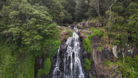 Unique-view-as-water-flows-from-a-natural-creek-bed-as-it-tumbles-over-moss-covered-waterfall