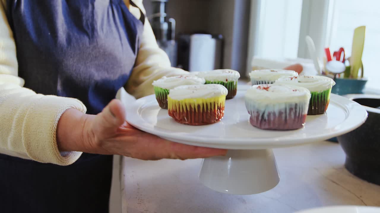 케이크 스탠드 4k 4k와 함께 컵케이크를 들고 있는 애프론의 할머니