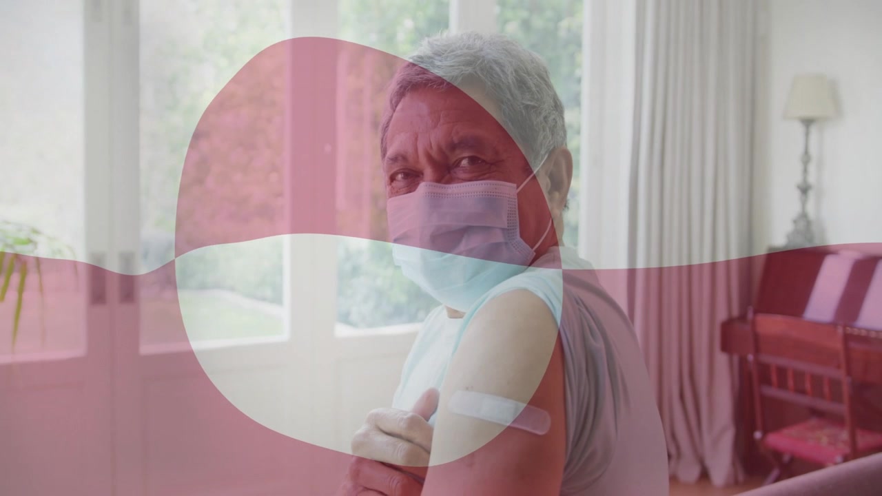 Senior man turning to camera post-shot, placing hand on bandage as red overlay drifting for health