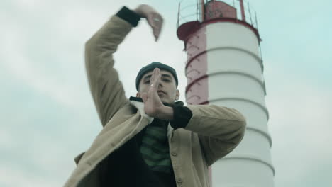 young man dancing vogue to camera outdoors