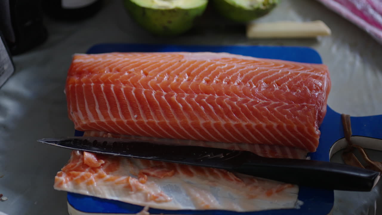 Natural light salmon fillet on cutting board with knife in home or restaurant kitchen