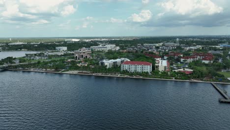 jetty and promenade along river bay in bradenton, florida. cloudy summer day. aerial wide shot. hospital and residential neighborhood in background. riverwalk splash park