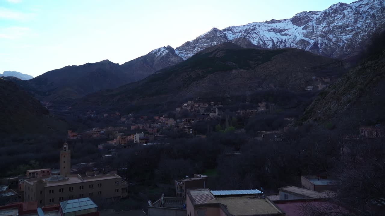 Imlil Village in Morocco near Toubkal Mountain glows in the soft hues of dusk, as the last sunlight reflects off the rugged peaks