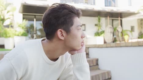 아시아 남성 십대 는 정원 에서  ⁇ 은 날 에 앉아서 휴식을 취하고 있다