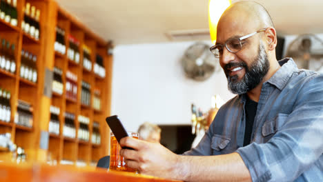 Hombre-Feliz-Usando-Teléfono-Móvil-Mientras-Toma-Cerveza-En-El-Mostrador-4k