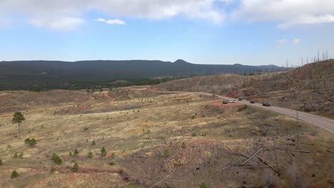 vista aérea de un grupo de vehículos que conducen a lo largo de una carretera de montaña remota en el bosque nacional pike, montañas rocosas, colorado