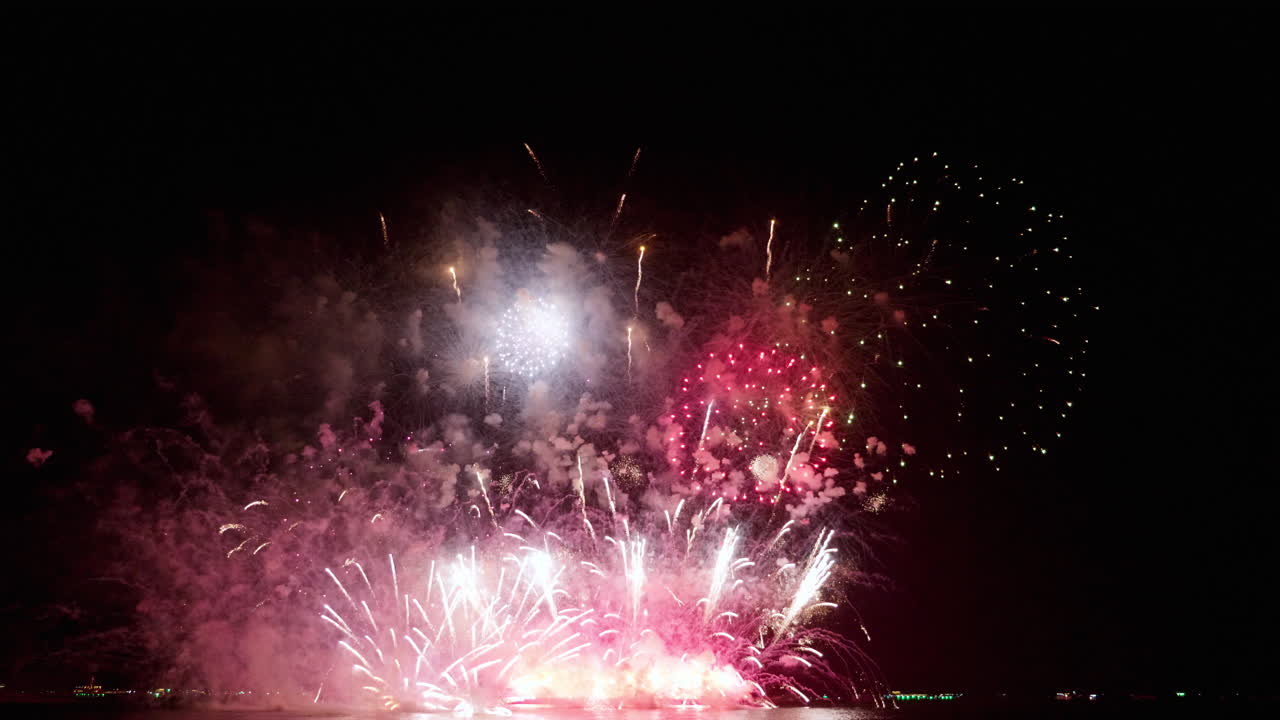 태국 파타야 국제 불꽃 축제 2023에서 해변에서 사람들이 지켜보는 바다에서 절정에 도달하는 불꽃놀이의 더 가까운 처