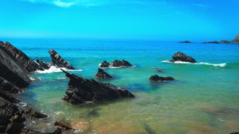 con un fondo azul profundo del cielo, el agua del océano atlántico se encuentra con la costa del algarve.