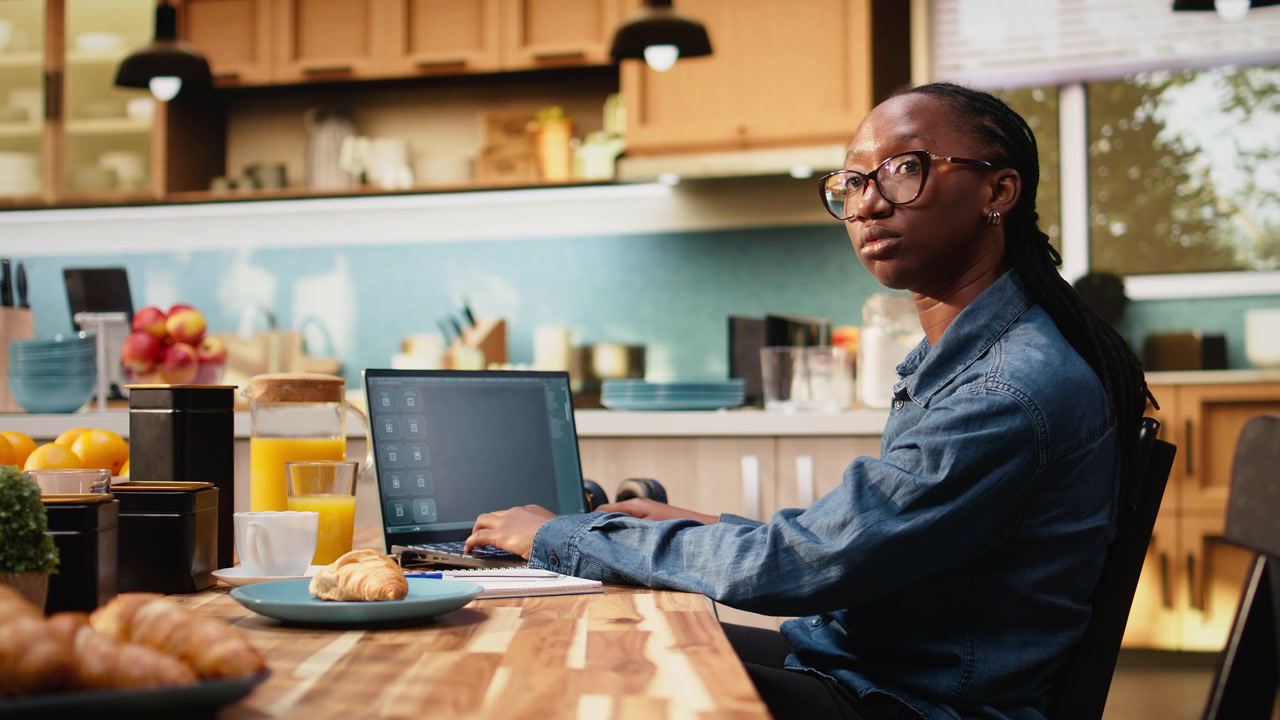 Giovane donna che comunica con un assistente virtuale AI sul laptop a casa