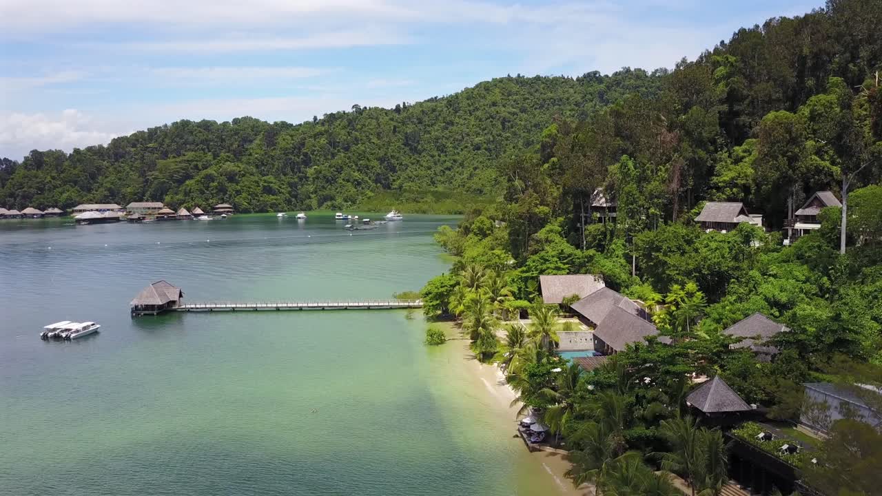 Aerial view forward over the pier towards the boats on anchor at Gaya Island,Kota Kinabulu,Malaysia.