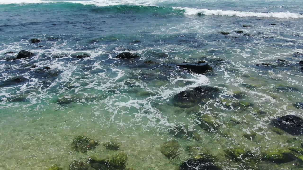 playa rocosa con olas rompiendo en un hermoso día de verano, agua cristalina