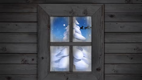 wooden window frame against snow falling over christmas tree on winter landscape