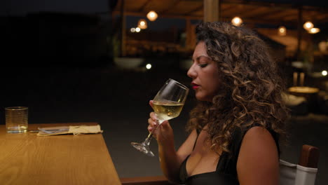 woman drinking wine at the beach resort before the dinner