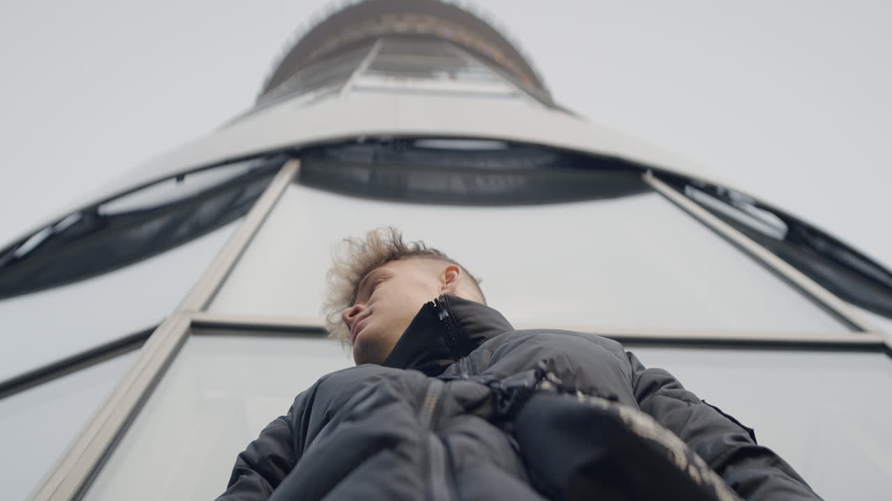 현대 건물 앞 에 있는 젊은 남자