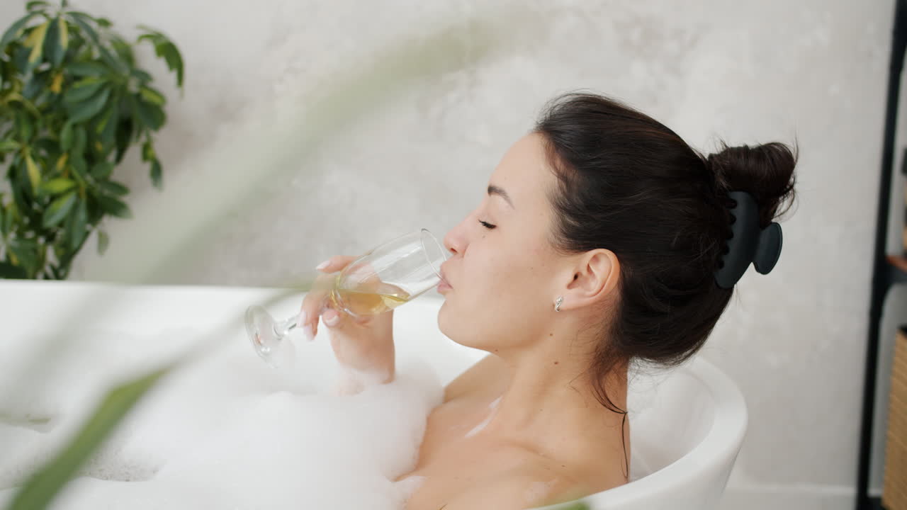 Woman Relaxing in a Bubble Bath with a Glass of Wine