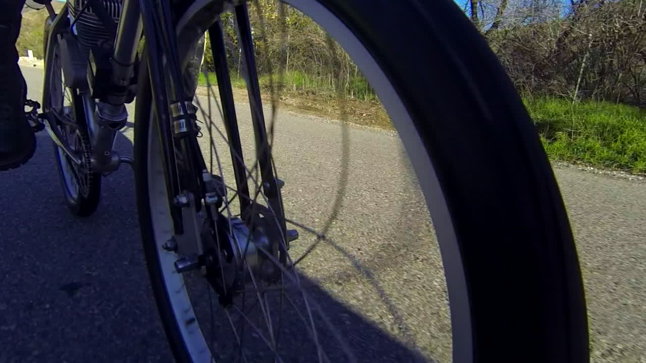 2차선 도로에서 시골을 통과하는 전동 자전거의 바퀴를 닫습니다