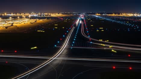 night view of an airport runway with light trails