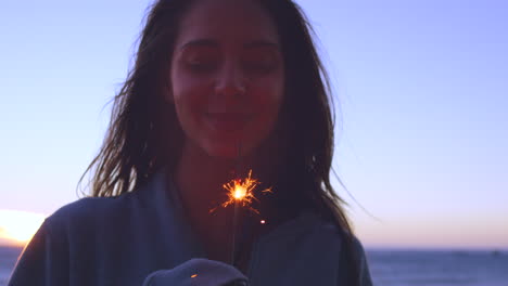 woman celebrating sunset with sparkler