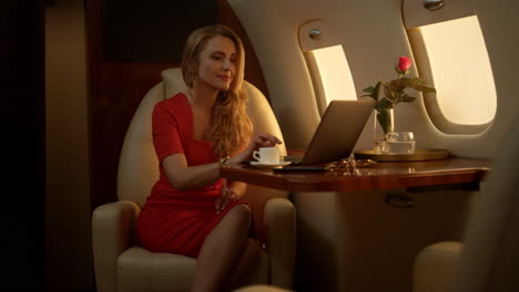 entrepreneur working laptop computer on corporate first class journey alone.