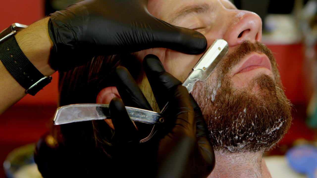 Man getting his beard shaved with razor 4k
