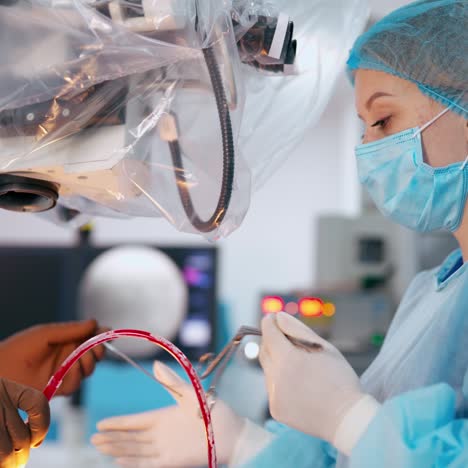 side view of a female assistant in medical uniform. medical worker assist surgeon during operation on the modern equipment in clinic.