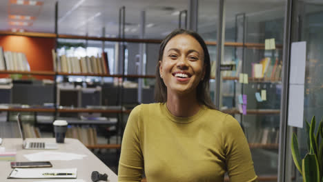 Portrait-of-happy-biracial-businesswoman-in-empty-office