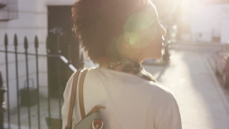 beautiful mixed race woman using smart watch technology walking through city