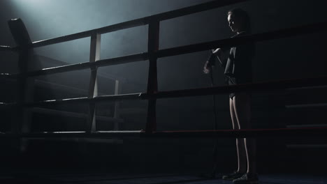female boxer standing in a dramatic boxing ring