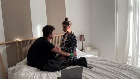 couple sitting on bed in bedroom
