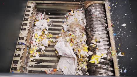 overhead shot of plastic waste being shredded in a waste recycling plant