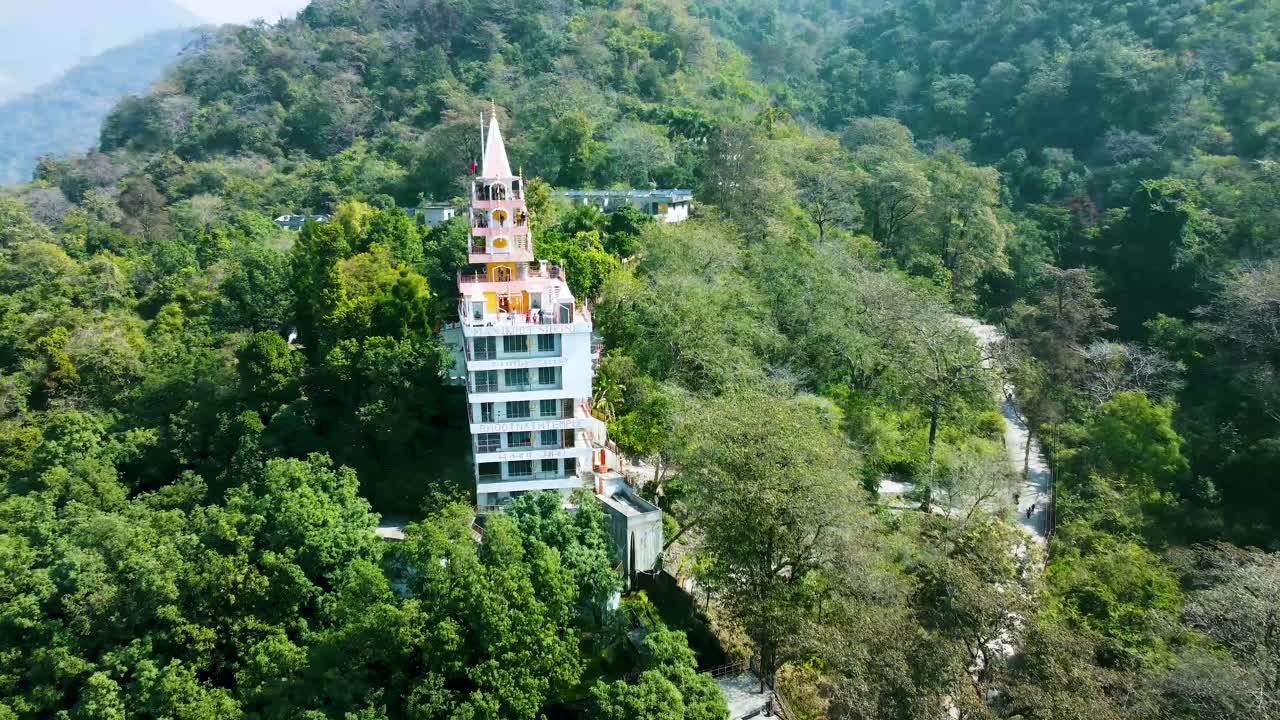 aislamiento de un templo hindú de varios pisos en el medio de los bosques desde diferentes ángulos. se toma un video aéreo en el templo de bhutnath, rishikesh, uttarakhand, india, el 15 de marzo de 2022