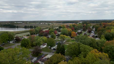 a neighborhood with trees in full fall colors near a tranquil lake