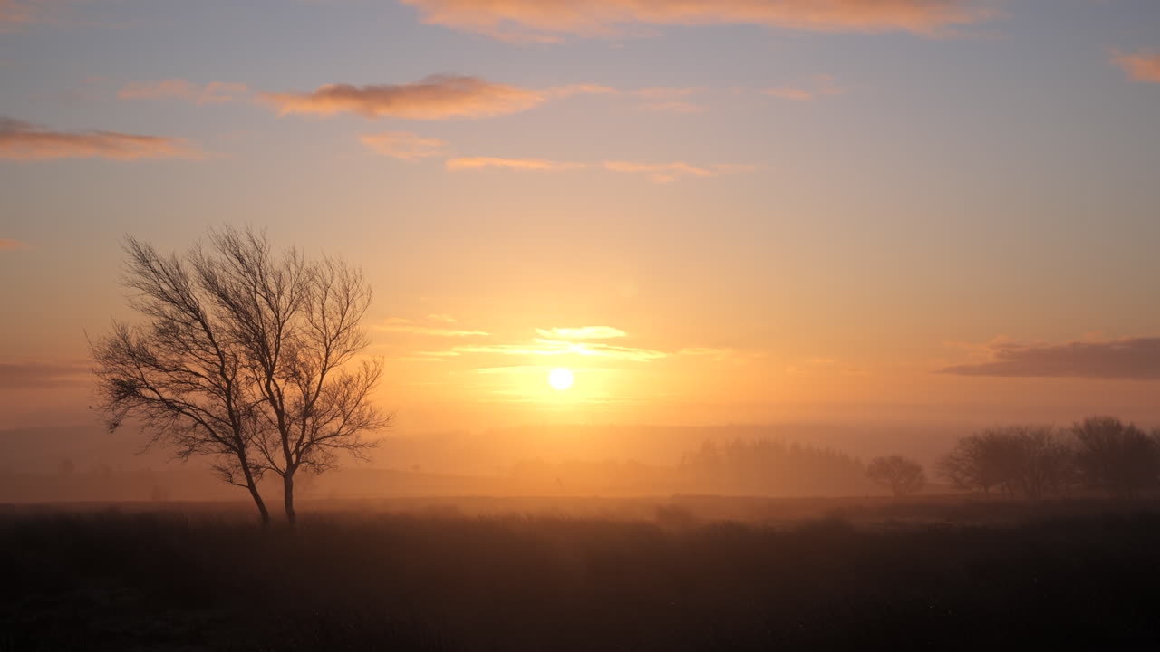 un hombre caminando a través del páramo en una mañana de otoño británico durante el amanecer